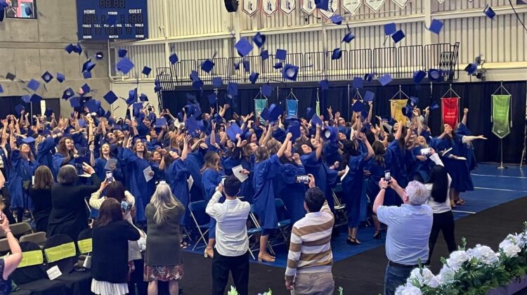 Hundreds of Students Jubilantly Tossing Graduation Caps Into the Air
